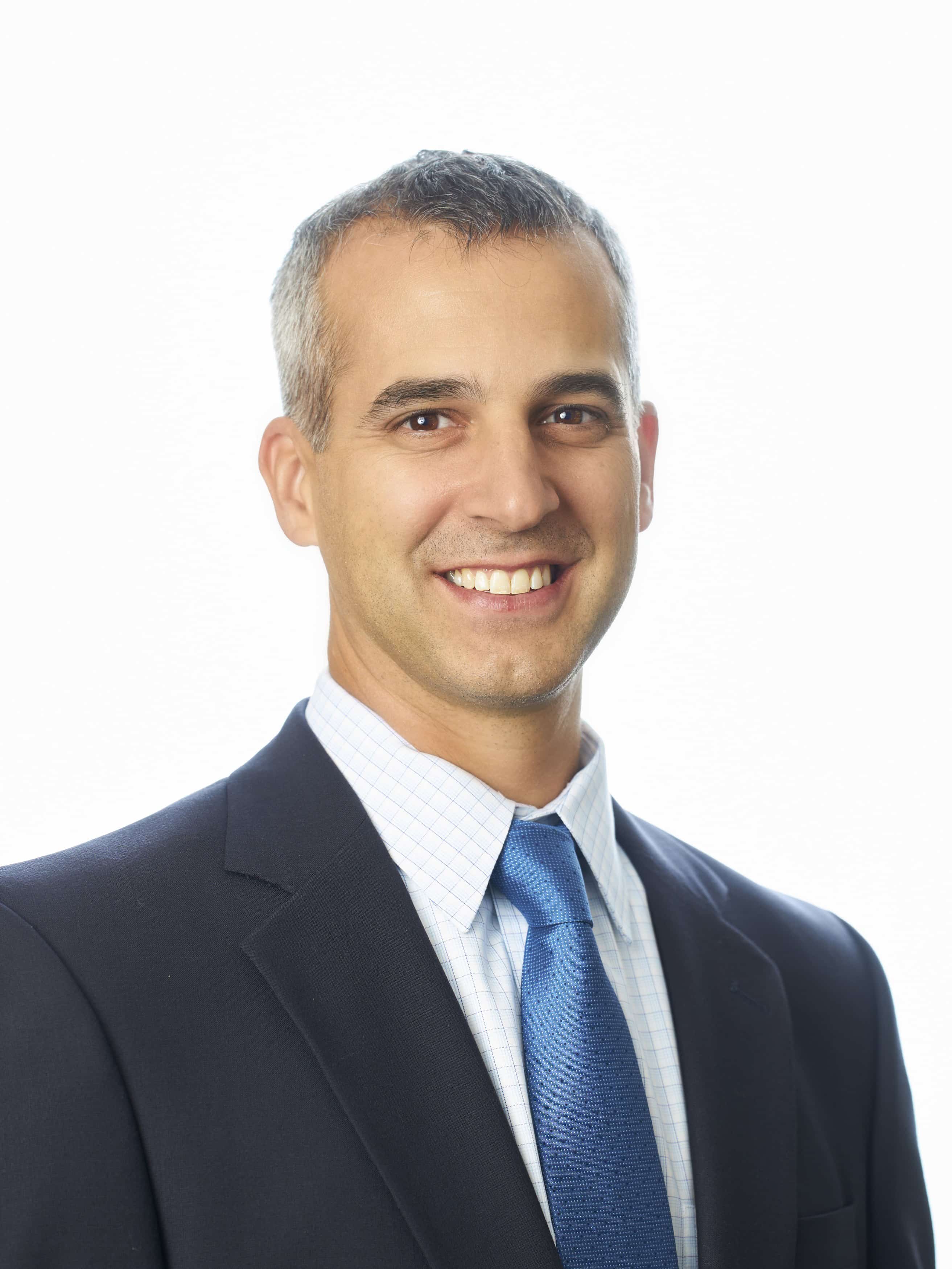 Man in suit and tie smiling.