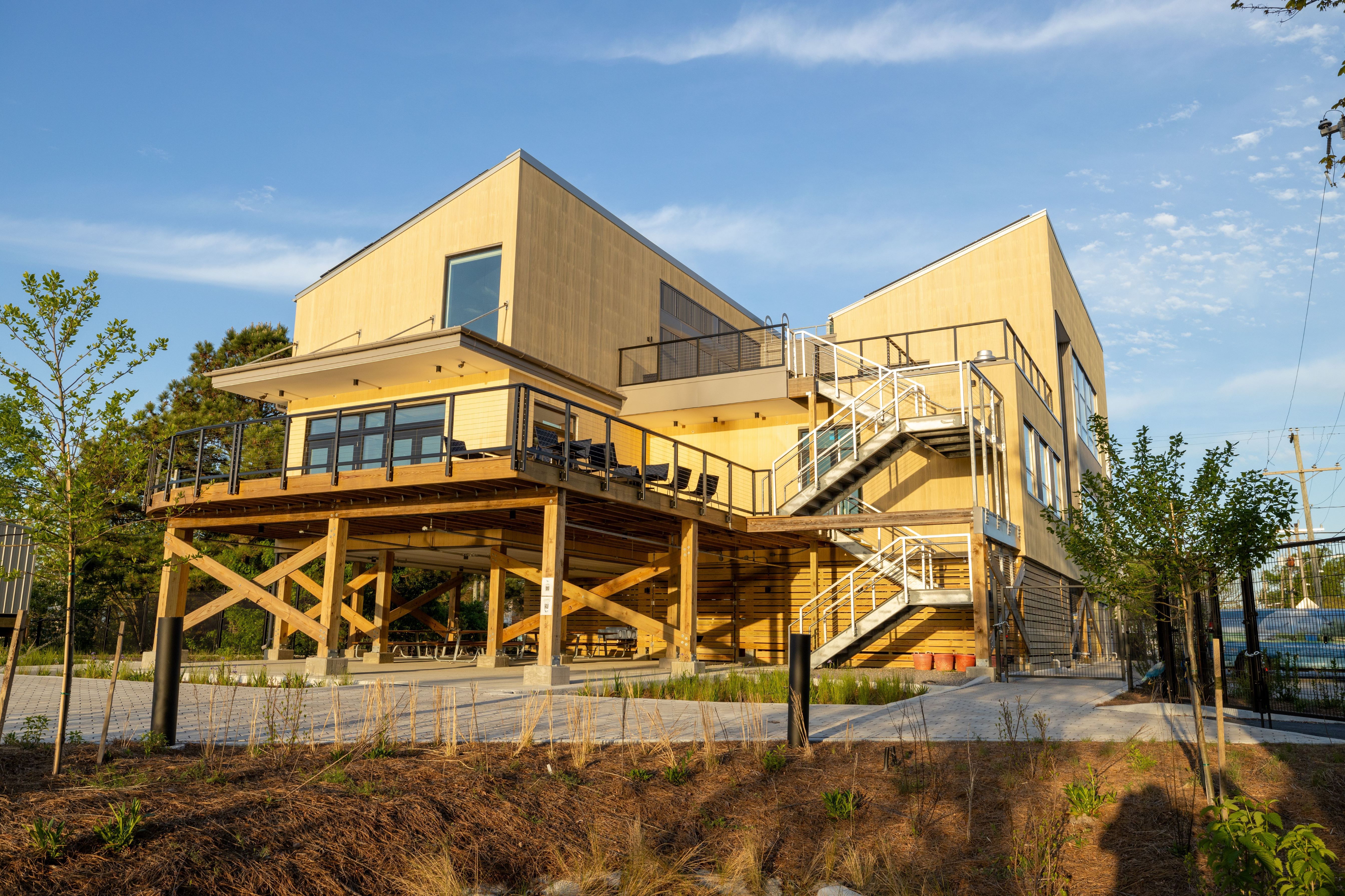 Exterior view of sustainability award winning Elizabeth River Project Ryan Resilience lab. Consisting od steep roofing and wood facade, large decking to look over the river.